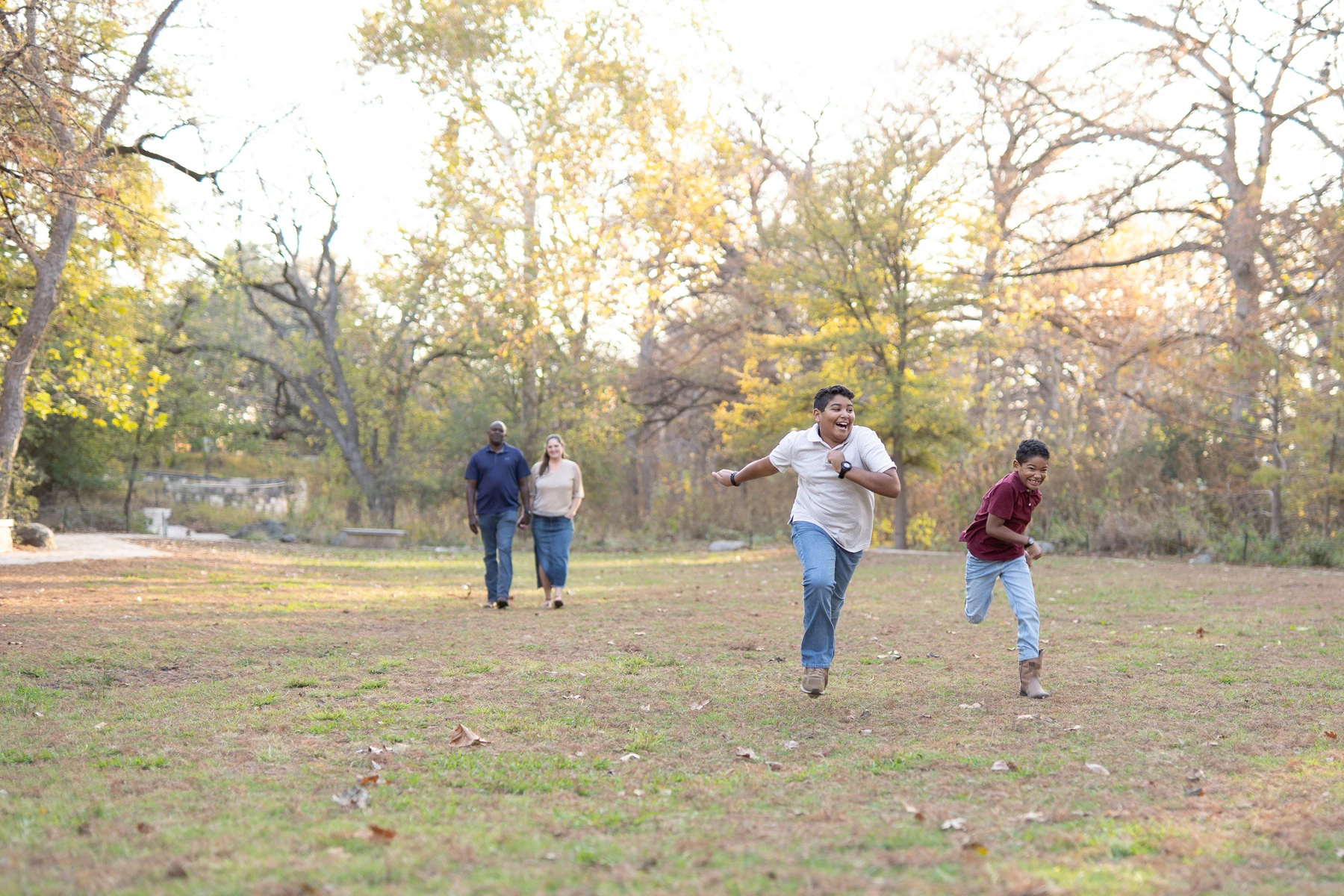 Family walking hand in hand through a golden meadow at sunset